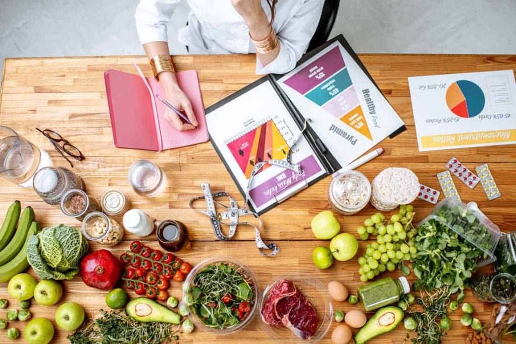 A woman is sitting at a table with a lot of food on it.
